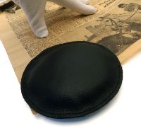 Circular leather paperweight